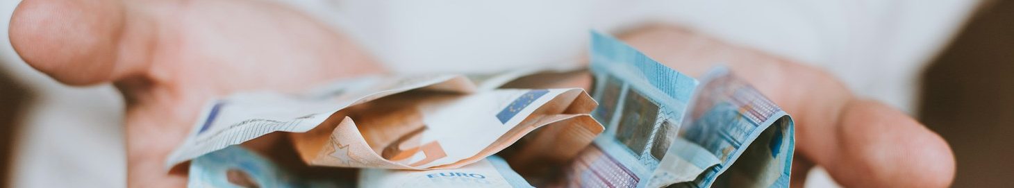 Hände halten eine Mischung aus Geldscheinen.